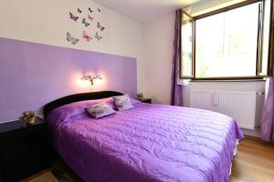 拉斯托瓦卡Apartment Mlađen的紫色卧室,配有带紫色棉被的床
