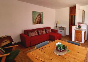 厄尔·坎皮洛·德·罗达尔Casa Biank的客厅配有红色的沙发和木桌