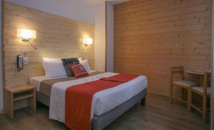 圣拉里苏朗奥里利亚酒店的一间卧室配有一张床和一张桌子及电话
