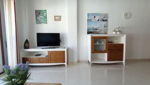 厄尔梅达诺alquilaencanarias Tio Claudio Beach的一间客厅,客厅内配有一台电视,位于一个木制娱乐中心