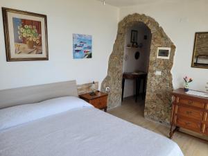 杰若米斯Villetta con piscina panoramica Belvedere Mari Pintau的一间卧室设有一张床和石墙