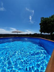 瓦莱迪坎布拉Rosinha Country House的一个带遮阳伞的大型蓝色游泳池