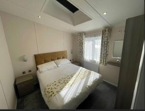 贝塞斯达C05 - The Ogwen Lodge with Hot Tub的一间卧室设有一张床和一个窗口