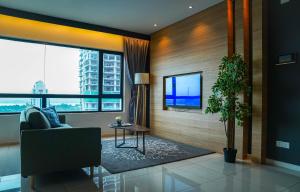 新山Suasana Lifestyle Suites by Keystone的客厅配有电视、椅子和桌子