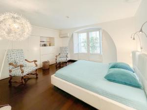 波尔多Appartement 2 chambres avec Terrassse en Hyper centre的一间白色卧室,配有一张床和两把椅子