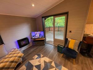 贝塞斯达L14 - Riverside Penrhyn Lodge的一间带电视和沙发的客厅