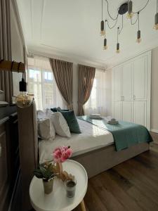 利沃夫Von Cruss apartments in Lviv的一间卧室配有一张床和一张桌子,上面有花