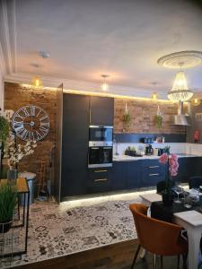 科尔内Albert Rd Aparthotel的一间设有蓝色橱柜的厨房和一间用餐室