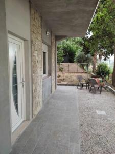 格拉达拉Villa Paoletti, appartamento confortevole nel cuore di Gradara的一个带门和桌椅的庭院