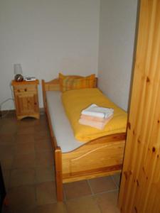 蒂蒂湖-新城Ferienhäusle Sonnenblume Titisee的一张小床,位于带黄色床单的房间里
