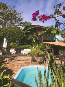 普腊亚罗萨Haleakala Hostel & Pousada的一座鲜花盛开的房子前的游泳池