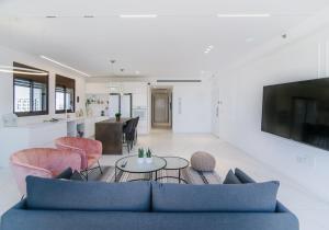 特拉维夫Yaffo Joy - Penthouse Apartment的客厅配有蓝色的沙发和桌子