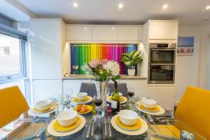 布莱顿霍夫Luxury at The Brunswick - Free Parking-4 bedrooms的一个带玻璃桌和彩虹的用餐室