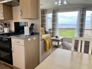 泰恩河畔纽卡斯尔New Sea View Platinum Caravan with Huge Decking的厨房和客厅,享有海景