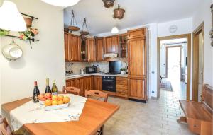Villa MarinAmazing Home In Montemerlo With 2 Bedrooms的厨房配有一张桌子,上面放着一碗水果