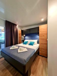 塞尔瑟Rosmarin&Olive Premium Mobile Homes的一间卧室配有一张大床和两条毛巾