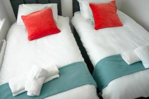 索利赫尔3 BED new build home with FREE parking BHX NEC HS2 CONTRACTORS FAMILIES的两张单人床,配有红色和白色枕头