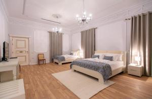 地拉那Vila Ferdinand Modern Rooms In Tirana's Center的一间白色的大卧室,配有两张床和吊灯