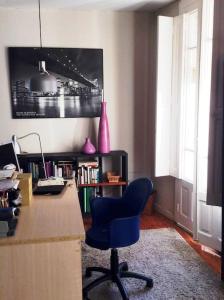 维戈Acogedor apartamento en el Casco Antiguo的一间房间,配有一张桌子和一张蓝色椅子