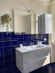 比耶拉Il Giardino Segreto的浴室设有白色水槽和蓝色瓷砖