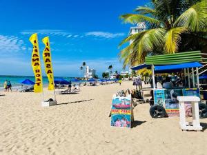 圣胡安Ocean View apt on Isla Verde in a 14th floor的沙滩上设有遮阳伞和标志