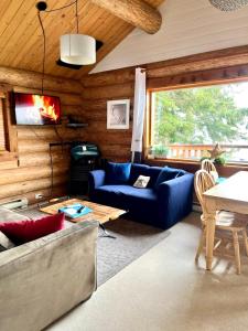 Gillies BayThe Beach House Texada - Waterfront Cabin的客厅配有蓝色的沙发和桌子