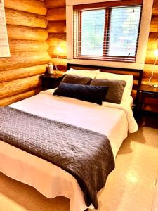 Gillies BayThe Beach House Texada - Waterfront Cabin的卧室在原木墙前配有两张床