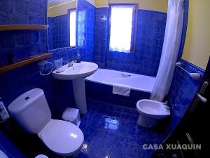 MoalCasa Xuaquin的蓝色瓷砖浴室设有卫生间和水槽
