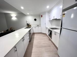 拜伦湾拜伦季公寓酒店的厨房配有白色橱柜和白色家电