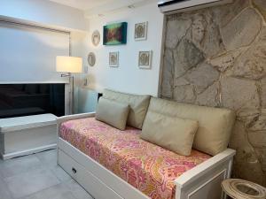 布兰卡港Casamia Studio的一间带沙发和石墙的卧室