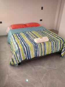 OibaCASA TOÑITA的一张带彩色条纹棉被的床