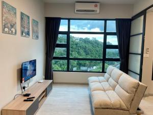 哥打京那巴鲁Sunset Seaview Vacation Condos @ Jesselton Quay的带沙发和大窗户的客厅