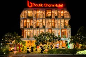 芽庄Boutik Cham NhaTrang Hotel的一座建筑,人们在晚上前走