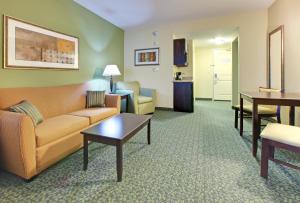 Covington科温顿智选假日酒店及套房的客厅配有沙发和桌子