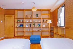 那霸Naha Gajumaru Apartment Hotel 401的一间卧室设有两张床和书架
