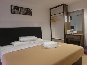 马六甲舒适图恩酒店的一间卧室配有一张带两个枕头的床