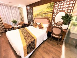 河内DE LA SOIE Hotel & Travel的配有一张床、一张桌子和一张桌子的酒店客房