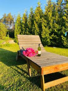 Bovkunсадиба доличі的一张野餐桌,上面放着一瓶葡萄酒和鲜花