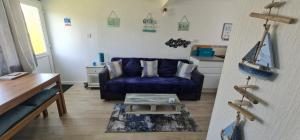 桑当Isle of Wight Chalet的客厅配有蓝色的沙发和桌子