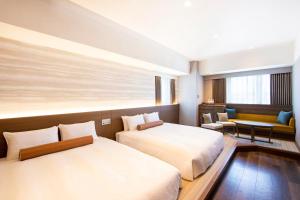 大阪唐草鼎盛酒店新大阪的酒店客房,设有两张床和一张沙发