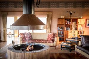 克拉塞利尔自然保护区Makumu Private Game Lodge的带沙发和火坑的客厅