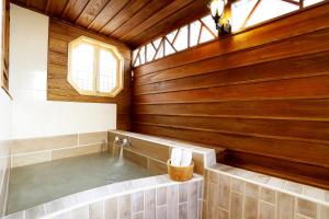 台北丽之汤温泉会馆的一间带热水浴缸和木墙的浴室
