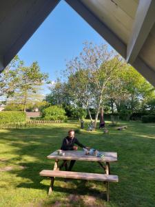 WeddeSlaaphutje BuitenWedde Westerwolde的坐在公园野餐桌旁的人