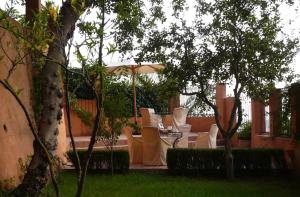舍夫沙万Dar Rass El Maa的庭院配有白色的椅子和遮阳伞。
