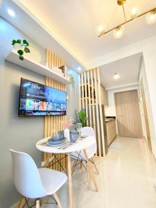 马尼拉Will’s Place @ Shore2 Residences Mall of Asia的一间配备有白色桌椅的用餐室