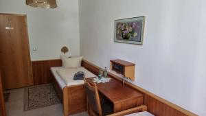 开姆尼茨Cafe Zur Talsperre的客房设有书桌和带电话的床。