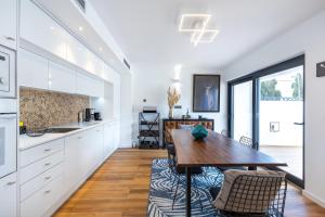 维拉摩拉Medusa Luxury Marina的厨房配有白色橱柜和木桌