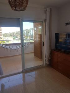 奥罗佩萨德尔马Marina dor Frontal 1ª línea的客厅设有滑动玻璃门和电视
