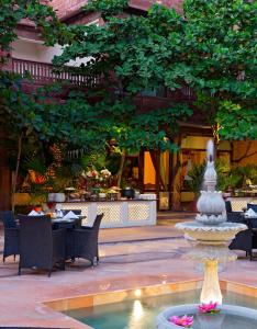 焦特布尔蓝班卡宫酒店的一个带桌椅的餐厅内的喷泉