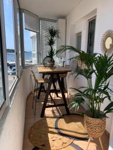 锡富尔勒普拉日Bel appartement sur le port du Brusc avec sa place de parking privative.的一间设有桌子和一些植物的用餐室